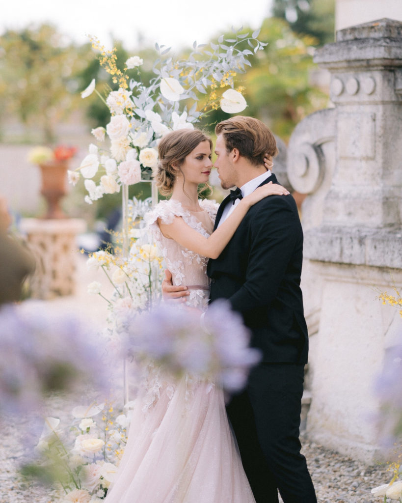 couple de mariés devant leur arche florale mis en scène par la wedding planner Amélie Pichon Weddings
