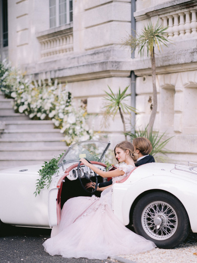 mariee et son mari dans une voiture vintage mis en scène par la wedding planner Amélie Pichon Weddings
