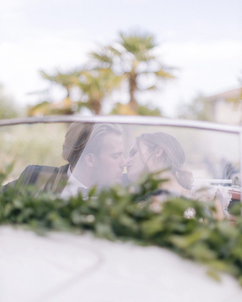 mari embrassant mariee dans une voiture vintage mis en scène par la wedding planner Amélie Pichon Weddings