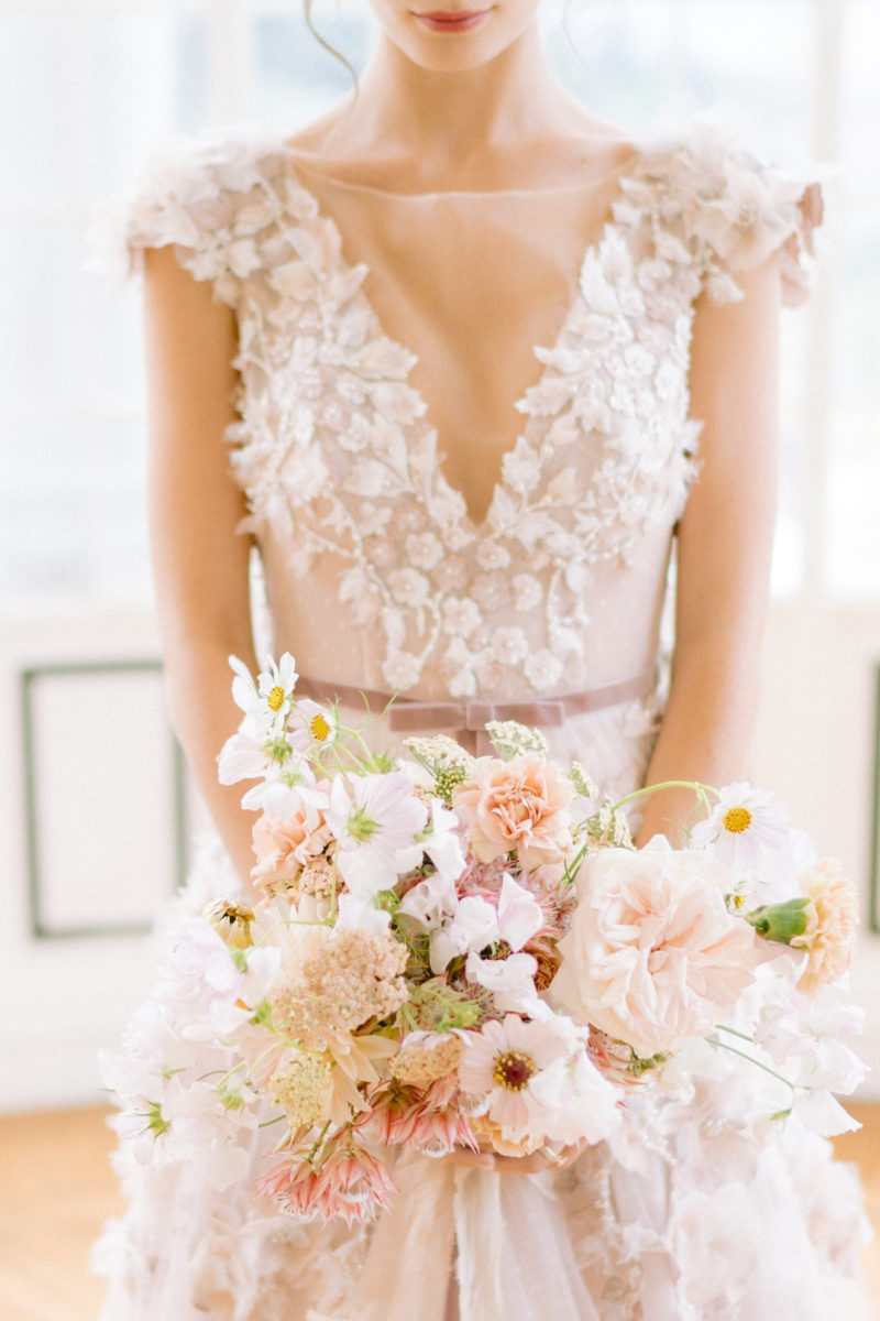 mariée en robe tenant son bouquet de fleurs mis en scène par la wedding planner Amélie Pichon Weddings
