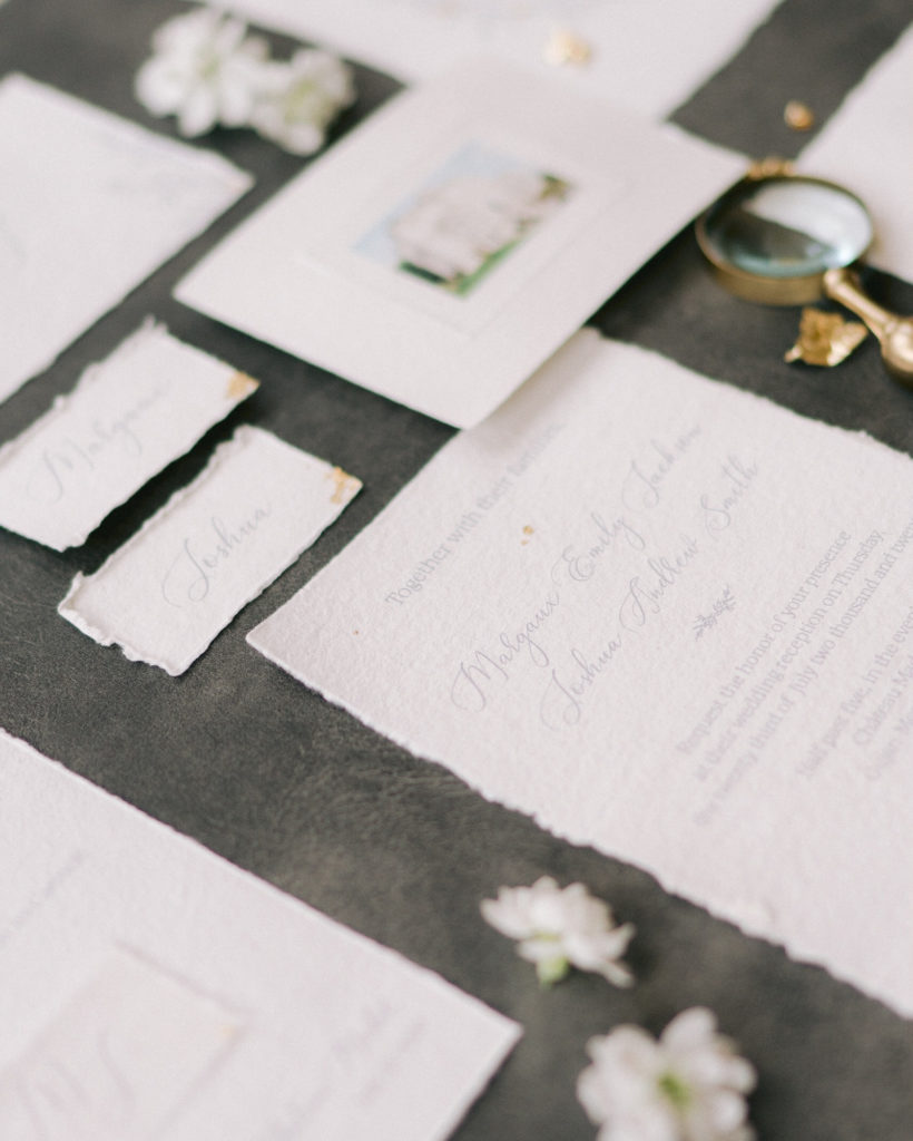 Flatlays papeterie de mariage avec des fleurs mis en scène par la wedding planner Amélie Pichon Weddings