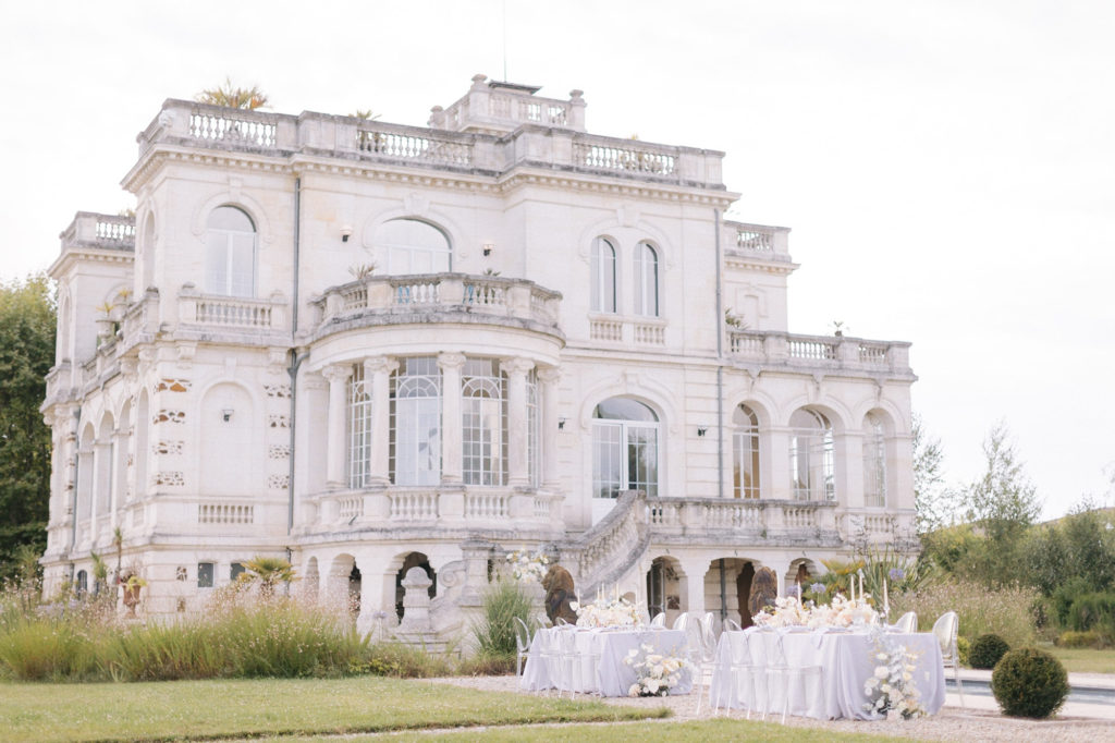 table mariage devant château mis en scène par la wedding planner Amélie Pichon Weddings