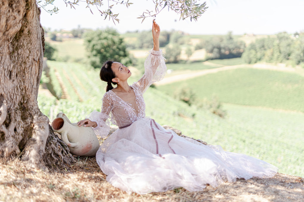 Mariée allongée sous un olivier au milieu de vignes saint emilion mis en scène par la wedding planner Amélie Pichon Weddings