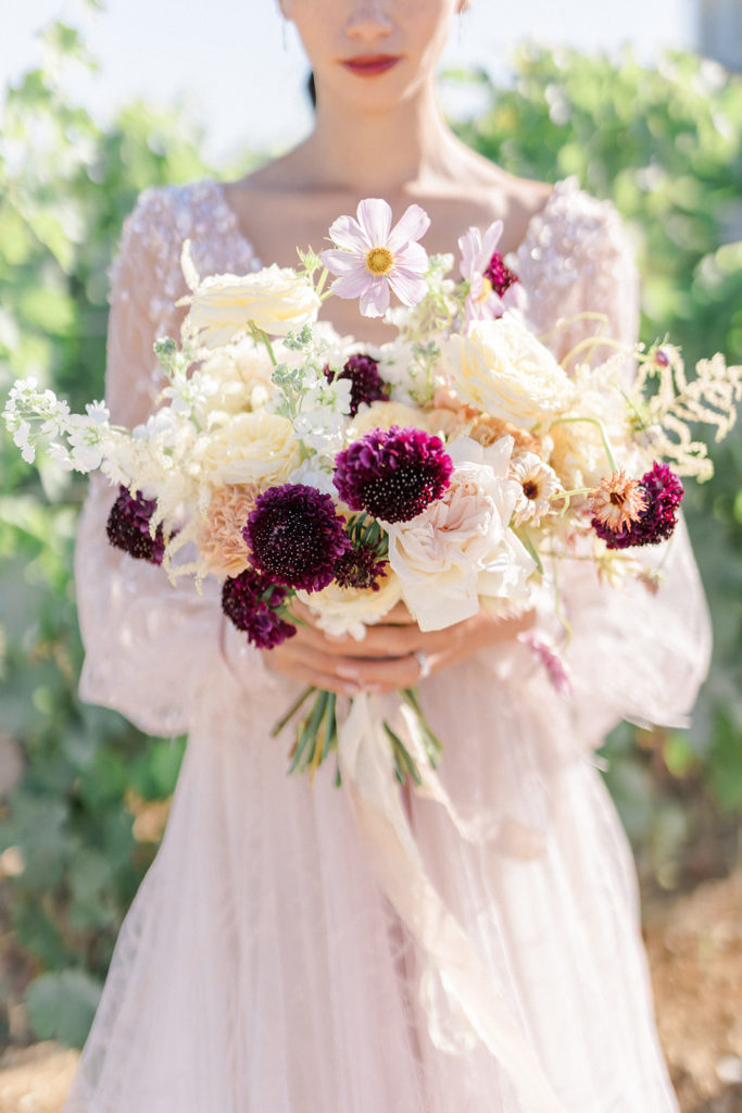 Mariée tenant bouquet fleurs naturelles mis en scène par la wedding planner Amélie Pichon Weddings