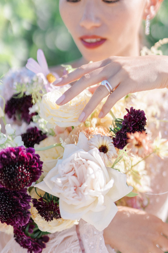 Mariée touchant son bouquet fleurs fraîches mis en scène par la wedding planner Amélie Pichon Weddings