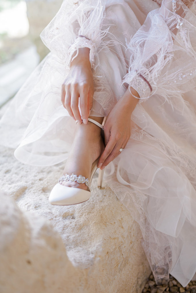 Mariée tenant sa chaussure mis en scène par la wedding planner Amélie Pichon Weddings