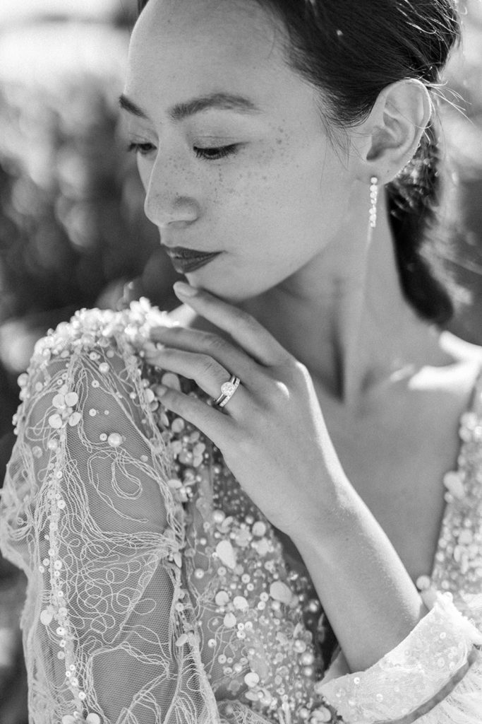 Mariée noir et blanc avec main posée sur son épaule montrant sa bague mis en scène par la wedding planner Amélie Pichon Weddings
